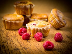 Raspberry almond muffins on wooden background