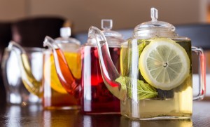 Three different coloured square teapots filled with herbal teas.