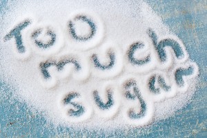 The words "too much sugar" written in sugar grains. Overhead view.