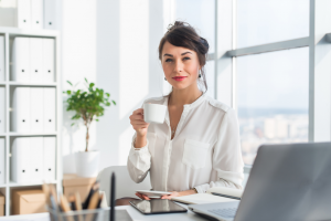 A woman in a white shirt drinking from a mug