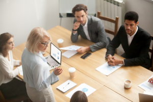 A woman speaking to a table full of people